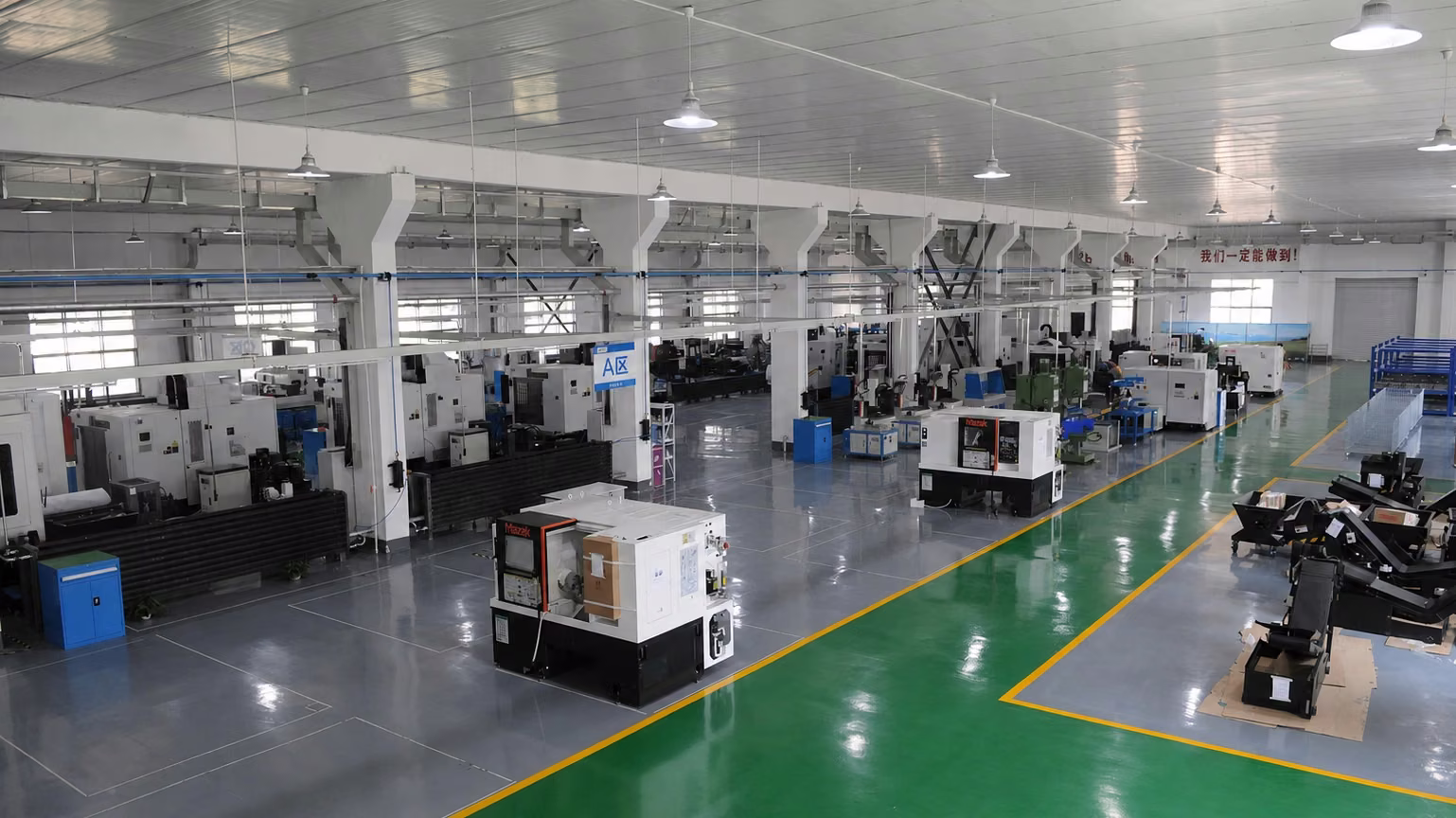 Wide CNC manufacturing floor with multiple production cells and open material-flow aisles