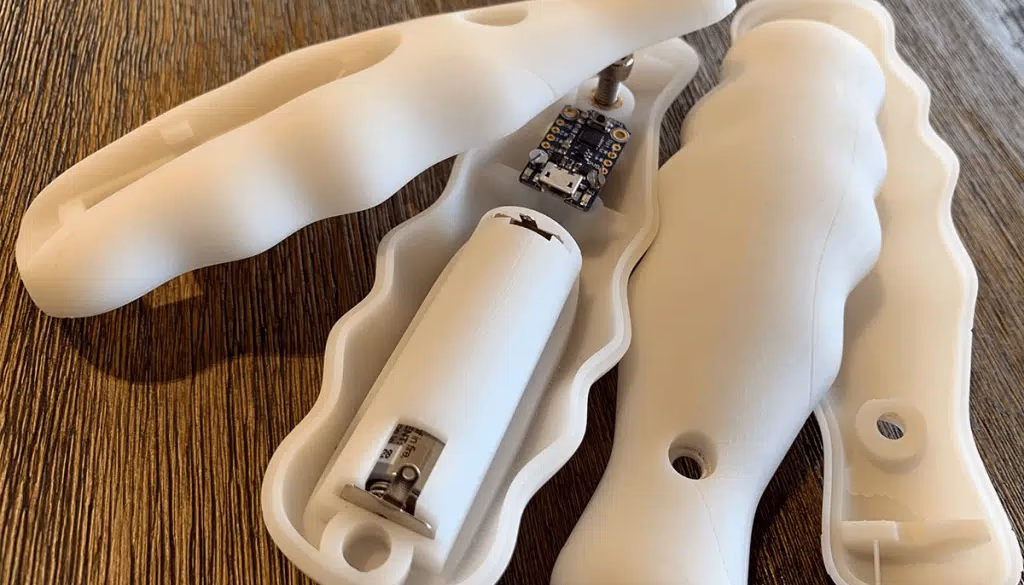 Open and assembled white SLA prototype housings shown with internal electronic components