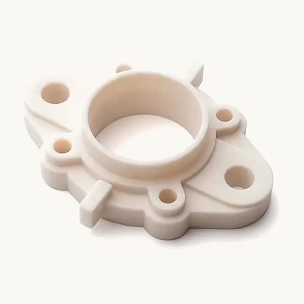 Single light ceramic-filled resin prototype with a central circular boss and mounting holes on a warm neutral background.