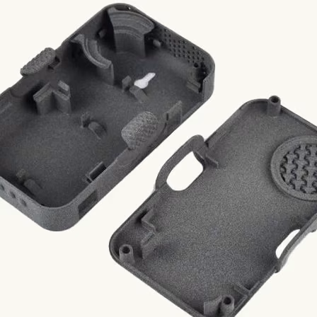 Pair of dark gray additively manufactured electronics enclosure halves with internal bosses and openings.