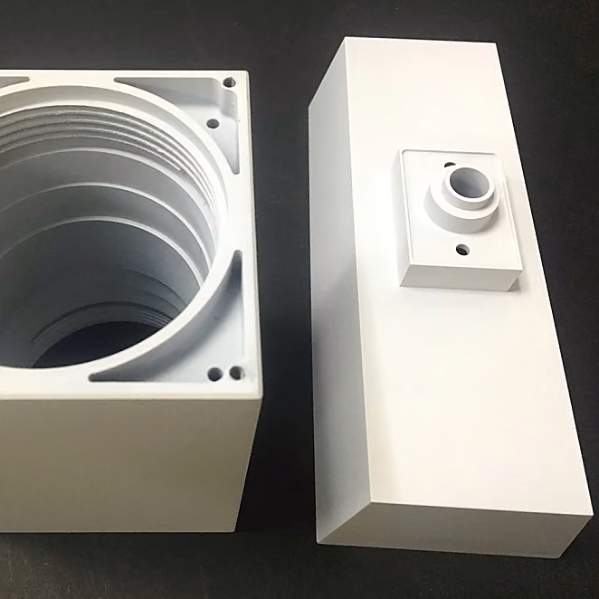 Large white prototype enclosure sections with deep internal cavities and raised interface features.