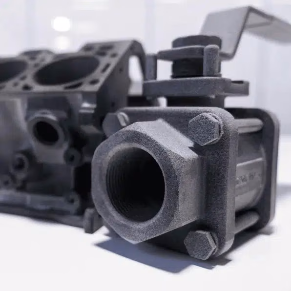 Gray MJF connector housing with a cylindrical opening, mounting flange, and integrated fastener positions.