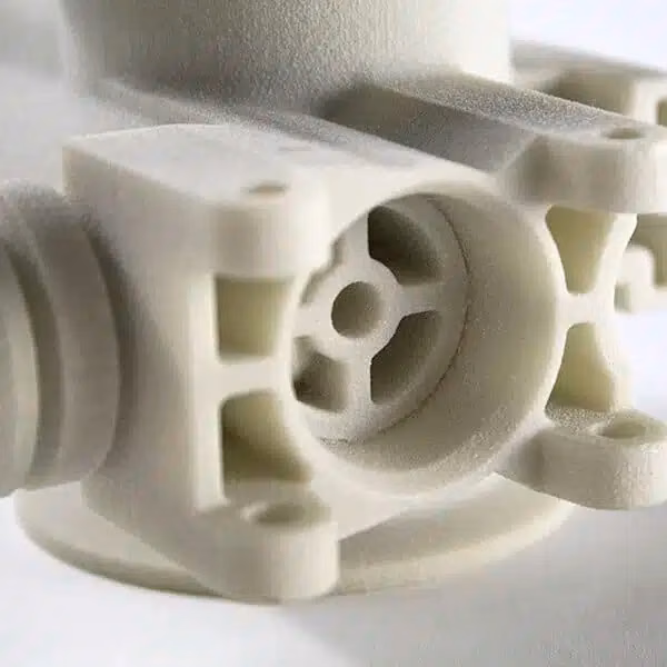 White SLS mechanical housing with internal passages, bosses, and complex nested geometry.