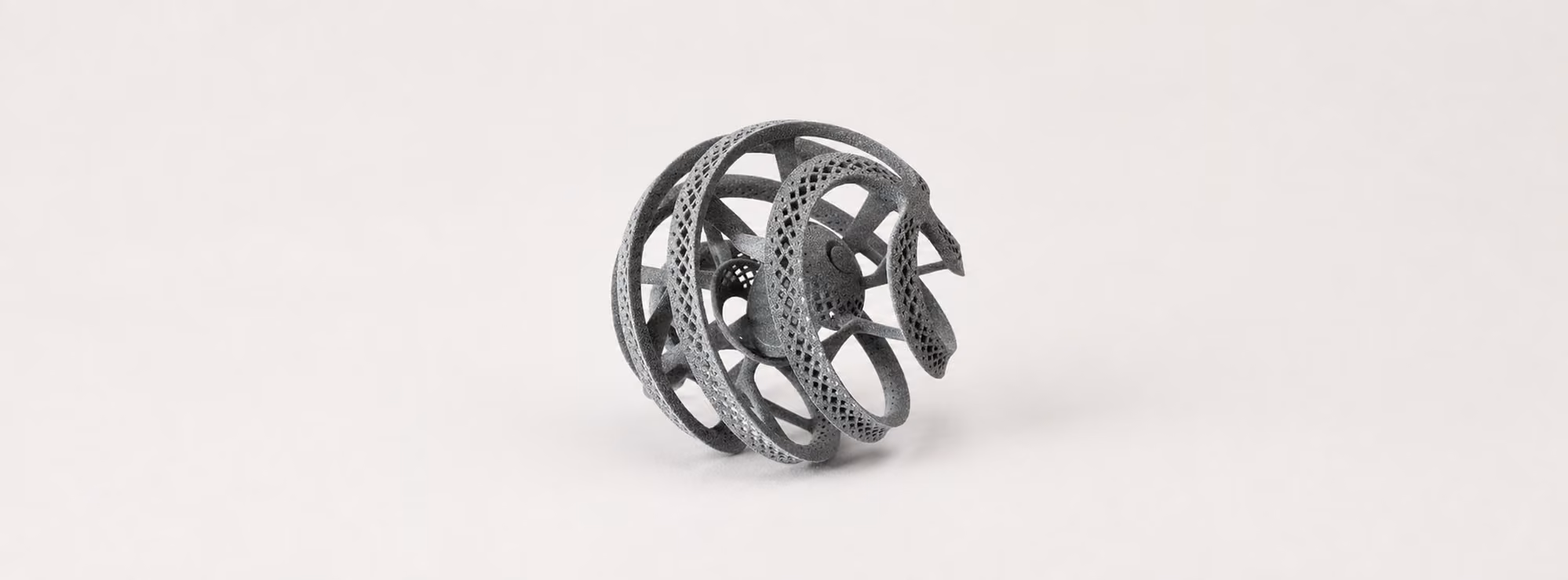 Complete gray SLS nylon lattice structure with interlocking curved ribs and perforated surfaces