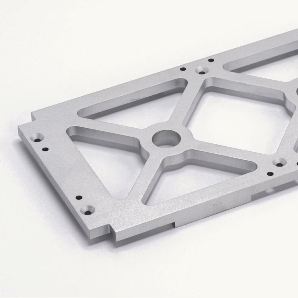Machined aluminum automation fixture plate with triangular weight-relief pockets and multiple mounting holes.