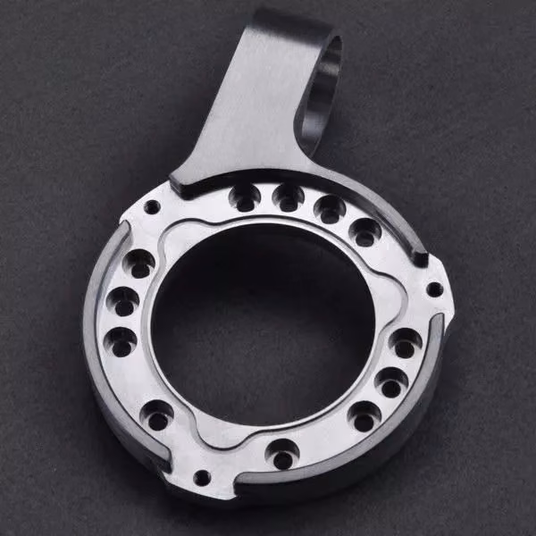 Silver machined aluminum rotary mount with a large central bore, circular fastener pattern, and external mounting arm.