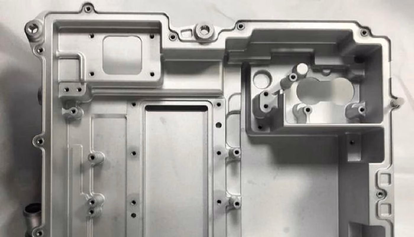 Close view of a precision-machined mold insert housing showing cavities, bosses, and mounting features