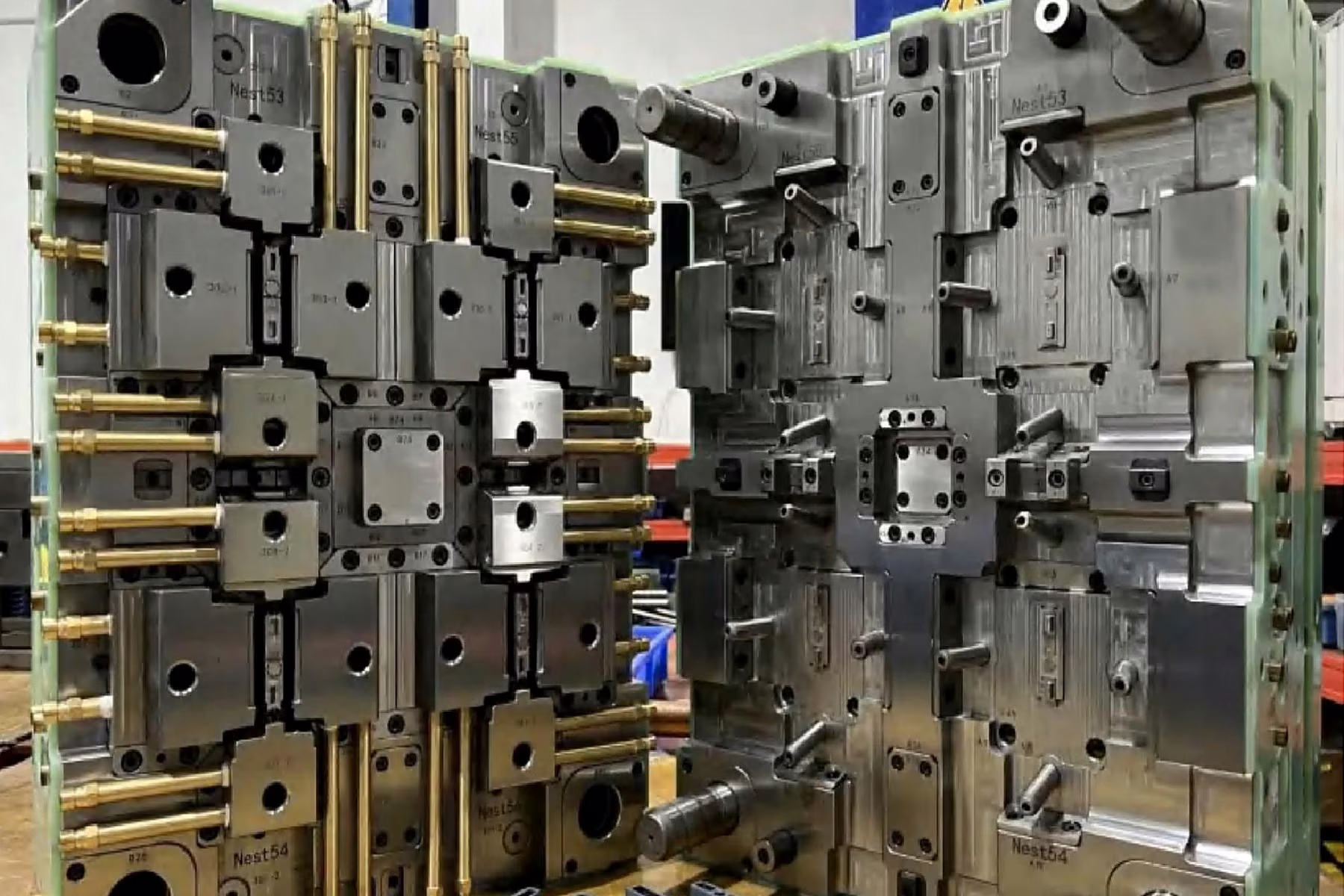 Open injection mold in a workshop showing accessible cavity, core, and tooling hardware
