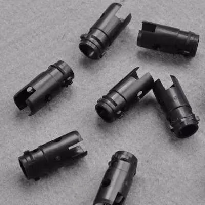 Small batch of black molded cylindrical connector bodies with internal passages and end features.