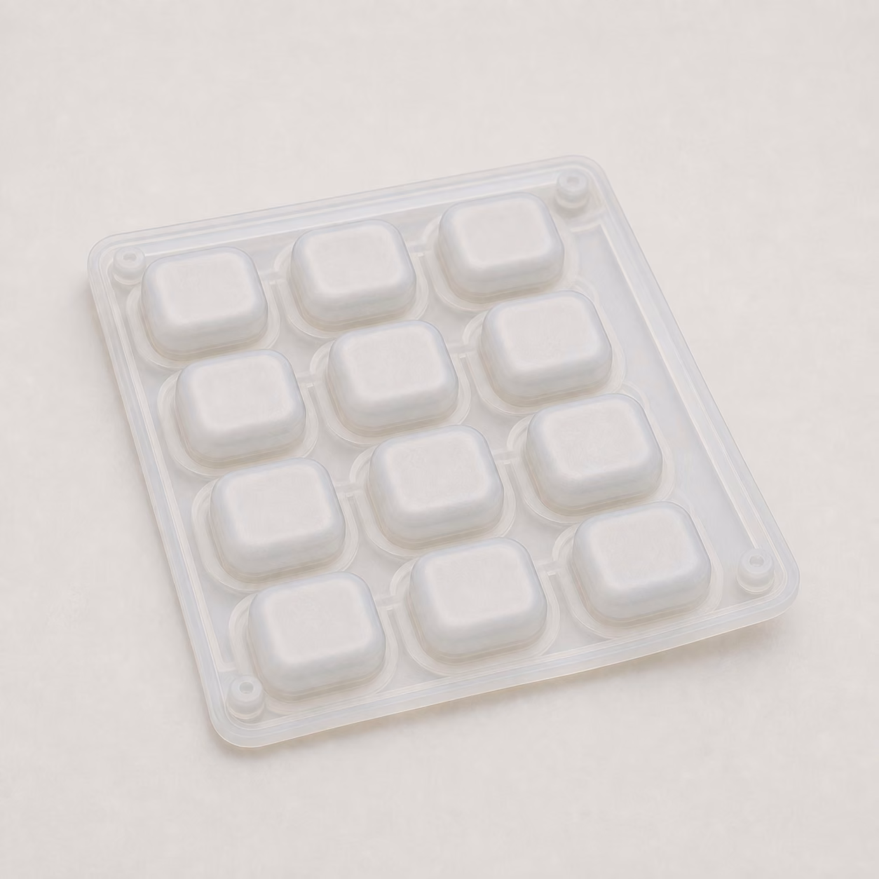 One-piece translucent silicone keypad membrane with twelve raised square button domes and flexible connecting webbing.