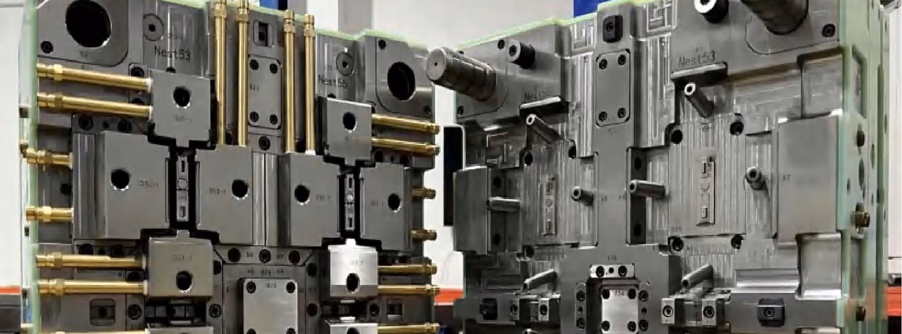 Open injection mold photographed in a production workshop with both tool halves visible