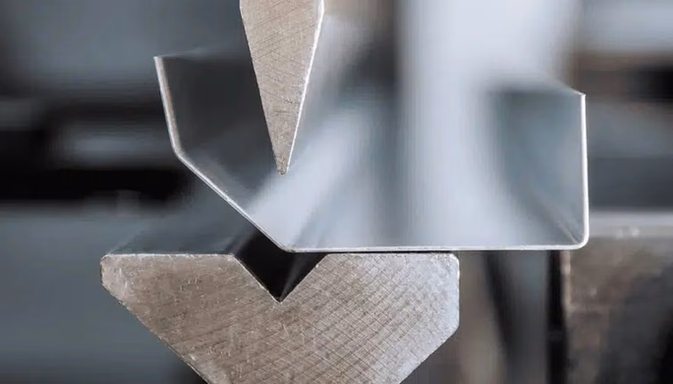 Press brake punch and die demonstrating controlled bend geometry in a sheet metal workpiece