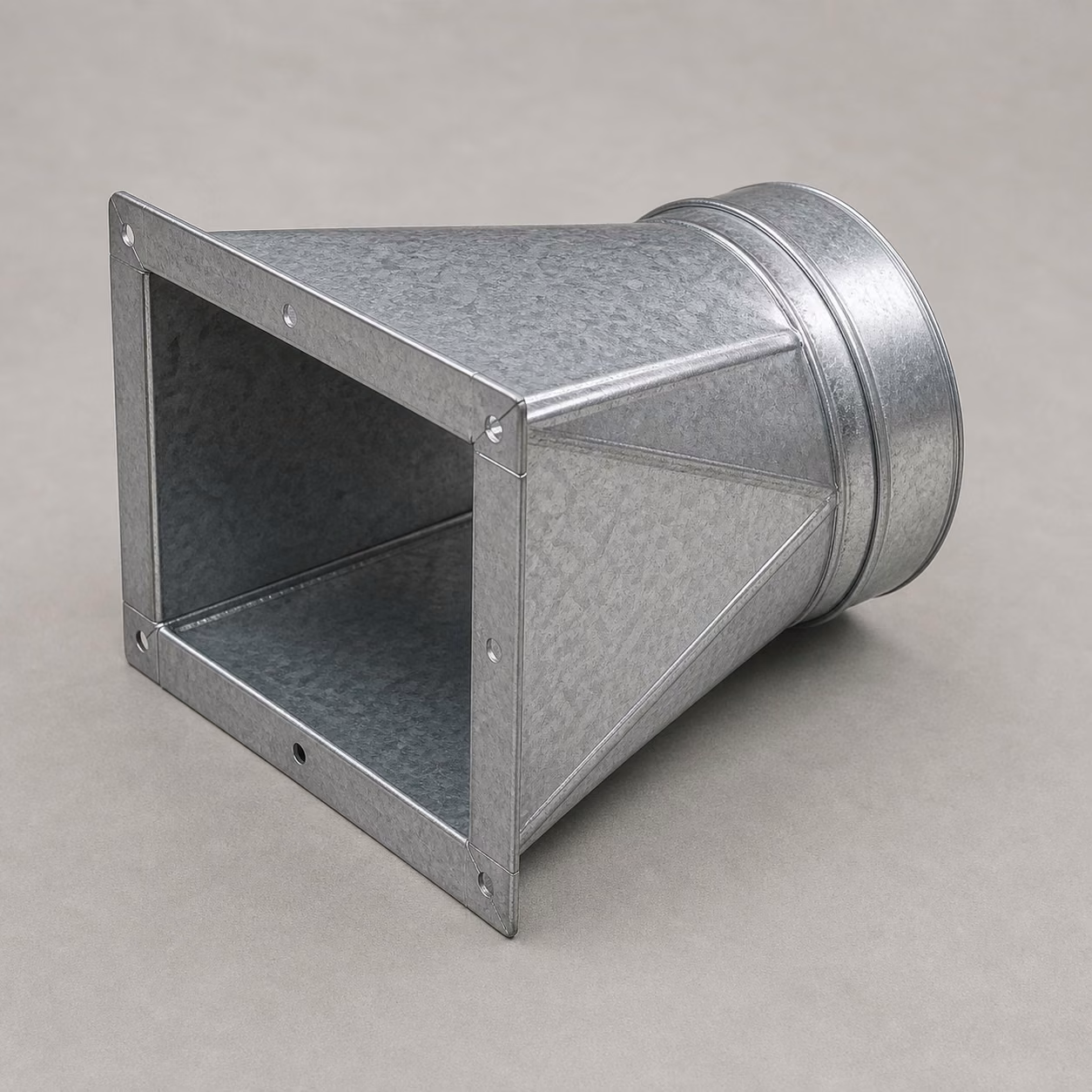 Galvanized steel HVAC transition duct with a rectangular flanged inlet, tapered formed panels, folded seams, and a circular outlet collar.