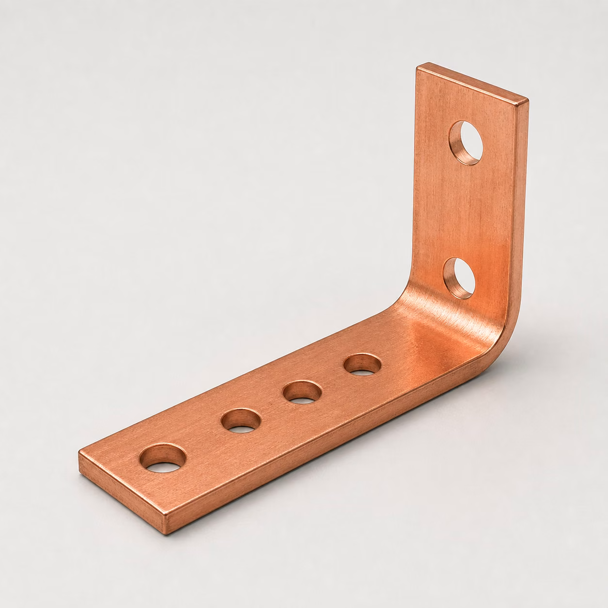 Formed C110 copper power distribution busbar with mounting holes, connection holes, smooth edges, and a controlled ninety-degree bend.